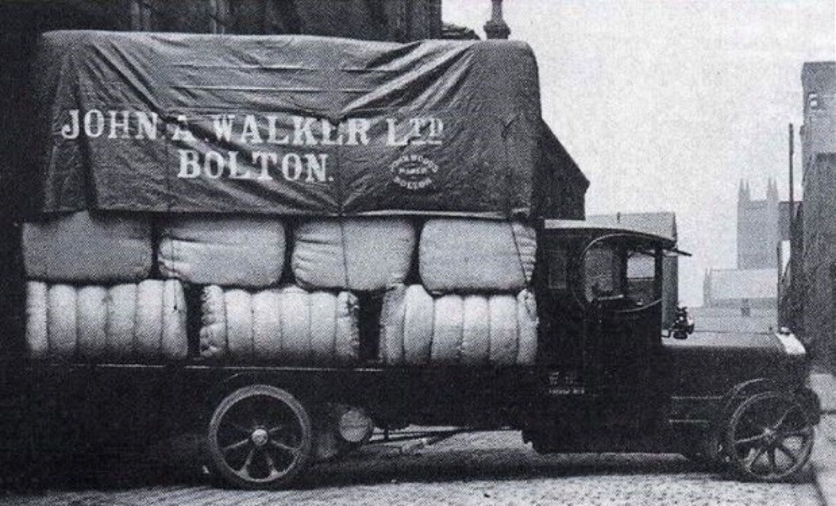 Photo of old vehicle containing raw cotton bales